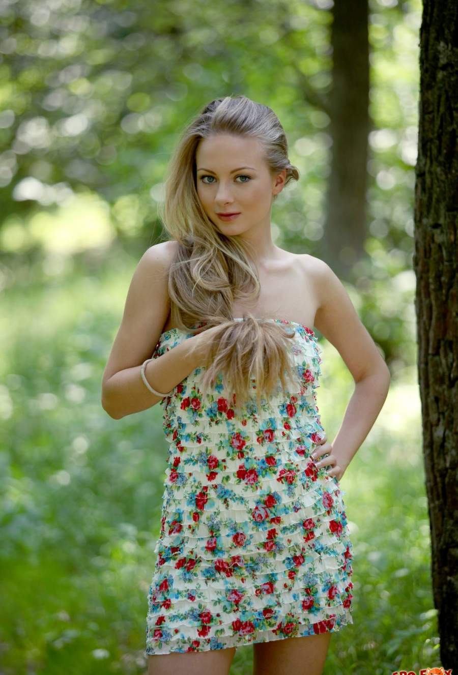 Фото: Красивая блондинка снимает платье в густом лесу